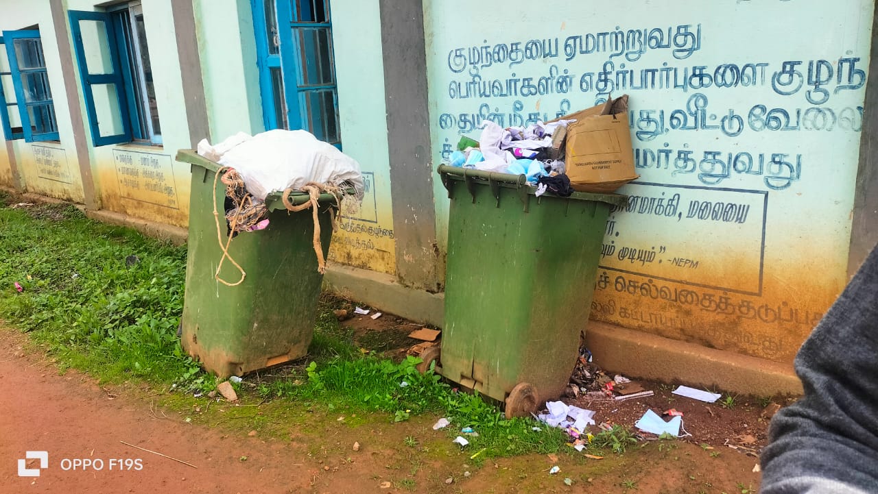 பள்ளி வளாகத்திற்குள் வைக்கப்பட்டு இருக்கின்ற குப்பை தொட்டியில் குப்பைகள் வடிந்து கீழே கிடக்கின்றன